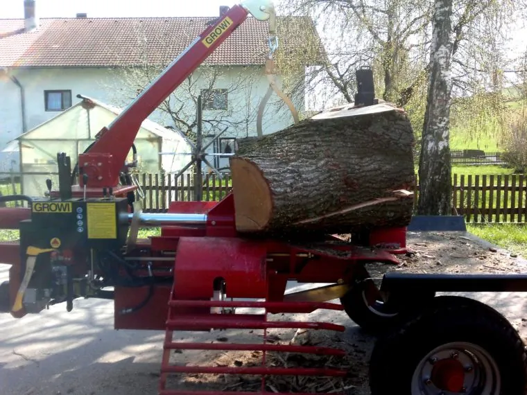 Großer Holzspalter mit Stammabschnitt vor einem Wohnhaus