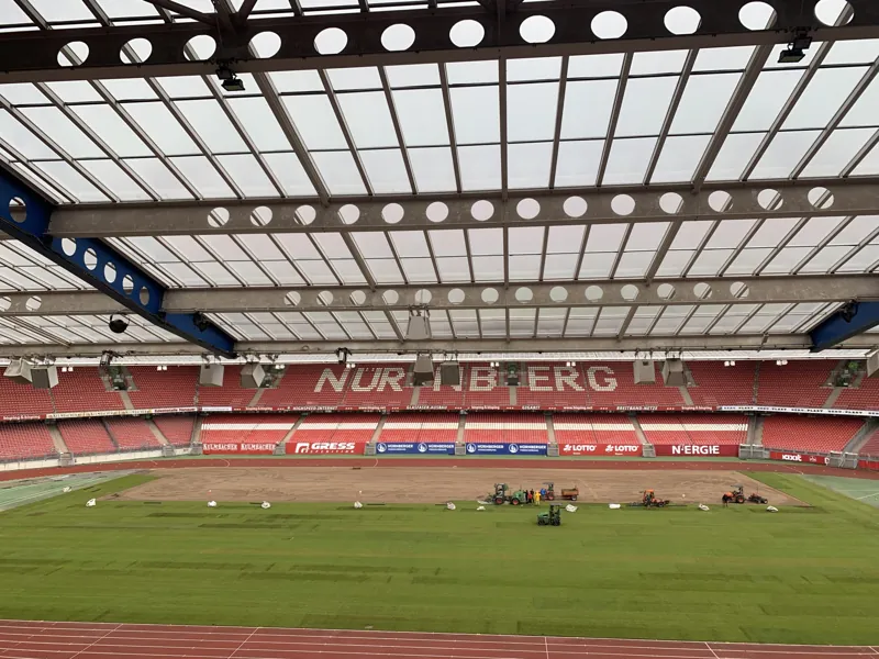 Blick über das Spielfeld eines Fußballstadions während der Rollrasenverlegung
