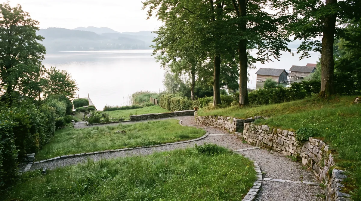 Hanggrundstück zum Starnberger See mit altem Buchen- und Eichenbestand, terrassiertem Rasen und Trockenmauern.